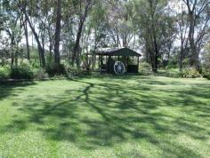 237B Northern Road ROMA QLD 4455 Situated on 5 acres, in a very secluded area is this beautiful brick veneer home. A formal entry at the front leads to the elegant lounge room with huge lead lighting windows. The open plan living takes in the family and dining areas plus the spacious Tassie Oak kitchen boasting pantry, microwave box, appliance hideaway and big island bench. There is no shortage of space with 4 ample B/I bedrooms (ensuite in main) plus office, separate shower with Spa bath, fully screened rear verandah, ducted air conditioning and 2 way wood heater. 9m x 6m LU powered plus air conditioned garage with extra 6 metre extension, 2 bay carport , bird & dog cages, green house & established gardens with own gazebo.