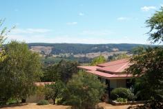 77 Bailey Heights Balingup WA 6253 HEAVENLY HEIGHTS This beautiful 4 bedroom, 5 bathroom homestead is nestled on 5 acres with stunning breathtaking views of the village of Balingup. The homestead would be ideal as either a family residence or a boutique style Bed and Breakfast. Finished with attention to detail, the spacious homestead has many classic character features. Jarrah floorboards throughout the living areas and the ornate ceiling roses create a timeless ambience. Timber French doors lead out onto wrap-around verandahs from which to view the surrounding countryside and rolling hills. A wide hallway leads down to the open-plan lounge and dining area. This living area has magnificent views of the surrounding countryside, and is heated in winter by a cosy slow combustion stove. It also has reverse-cycle air conditioning. The living areas and verandahs are an ideal place from which to view the winter mists slowly lift from the hillsides and valleys, or enjoy the stunning sunsets. The living area can be separated into two spacious sections if preferred. Large bi-fold doors can be closed to form a private (hosts) retreat. The kitchen is located in this section, and is well planned, with a free-standing substantial jarrah workbench, and generous cupboard and storage space. The kitchen also has a six burner 900 Smeg gas stove top with an electric oven, and dishwasher . The master bedroom is also located in this section of the homestead. All four bedrooms are spacious with French doors opening on to verandahs overlooking the peaceful front gardens. All of the bedrooms have ensuites, reverse-cycle air-conditioning and ceiling fans. Another separate bathroom has a shower, vanity and toilet. An additional large storage or linen room is accessed from the hallway. This delightful property even has the ideal 'his and hers' 'shed'! For every lady who has ever wanted her own shed, this would have to be one of the best! It is currently used as a studio/ massage room and has reverse-cycle air-conditioning and beautiful views of the valley and hills. The other is a double garage/shed with roller doors, concrete slab and power. The property also has a large Jadan six-seater spa and a garden gazebo to relax and enjoy the views. Terraced limestone walled gardens surround the home. The property also has a mature oak tree, and other deciduous trees, as well as established almond, fig, citrus, stone fruit and olive trees. Two 100,000L rainwater tanks provide water for the homestead. For more information, please contact either John or Sue on 97641089