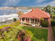 2 Derwent Lane Battery Point TAS 7004 Locality and convenience are at the fore in this prized 1914 character cottage in mainstream Battery Point. The only time you will get closer to the river is when launching your craft as the residence sits nicely back off the quiet thoroughfare that runs to water's edge. This is privileged Battery Point as your front entrance acts as an extended driveway that slopes gently to the waves lapping at a small reserve and jetty to host a range of marine activity. Back at the house, a cottage facade with wrap verandah with elaborate timber decoration sets the scene for a valued front lawn that provides a serene launch pad for spectating river activity and entertaining. The space and size of the dwelling and surrounds is one to truly entice with 645m2 on a large and sheltered block for inner city blue chip location. These desirables are hosted favourable through sheltered nooks and courtyard to appreciate seclusion from the neighbourhood that sprawls beyond your established shrubbery and border. A gated fence extends your perimeter to a sizable reserve over your back fence. Inside, the residence backs up the class and fortune of its exteriors with original remnants held in high regard and restored to their former glory. Original Baltic floorboards roam throughout the house supported by iconic timber detail, exquisite fireplaces, picture rails and an arch that sets the standard the moment you enter the house. Owners have taken their hand to gently transition the property into modern living opening up space and light whilst maintaining the character features that continue to enchant and charm. The main living with classic broad full-length windows dictates the mood as it extends towards dining and the kitchen, connecting nicely and finishing with bay windows in a complete dominance of natural light. The hallway with its high ceilings and centerpiece arch guides towards two bedrooms or one master with additional living or study. Each possesses grand space and light with the master spilling into a radiant sunroom via French doors with separate entry off the main verandah. Working fireplaces and restoration of original floorboards and windows provide elegance and style. A compact laundry and modern bathroom with corner shower, bath and vanity have tastefully been brought into the modern era with decor and convenience. Under house storage or cellar opportunities round out a very alluring proposition. The residence is not heritage listed and a height covenant on the property in front delivers exclusivity and guarantee that your waterfront view will remain as long as you are the proud homeowner. So if you have been seeking Battery Point convenience with space and style to truly kick into the leisurely lifestyle then this elegant and charming 1900s aims to satisfy on every level.