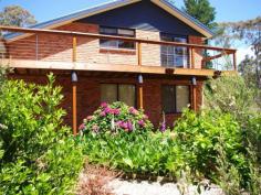 155 Coningham Road Coningham TAS 7054 Peacefully located in the beachside suburb of Coningham this 2004 built executive style family haven embellished by leafy surrounds with the added appeal of easy access to a private sandy beach is the perfect place to relax and unwind in comfort. A generous floor plan over 3 levels provides for a flexible living environment with plenty of room to move. The entrance level comprises of an impressive master bedroom with ensuite and an additional 2 bedrooms, both of good size with built in robes. Under stair storage opens to a further storage space ideal for use as a wine cellar. The second level is home to the stylish main bathroom and a fourth bedroom which could alternatively serve as a functional study. The upper level of this idyllic home boasts stunning sundrenched open plan living overlooking the array of botanical colour of the manicured gardens.