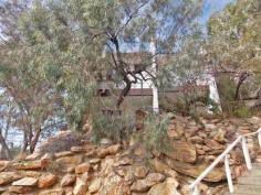 7/4 Aneura Pl Sadadeen NT 0870 Situated in the Sadadeen area close to schools, shops and transport is this end three level townhouse. The unit is almost at the top of the block with fabulous views of the surrounding areas and MacDonnel Ranges. Entry is to the front verandah which can double as a 2nd outdoor living area. The lounge area is tiled, boasts a reverse cycle air conditioner and has a handy storage area under the stairwell. The spacious second level area is tiled with the kitchen having electric cooking, dishwasher and ample cupboard and bench top space. The internal laundry is on this level as well and also a second toilet. Up the stairs to the top level you will find two bedrooms both with carpet and built in wardrobes. The main bathroom has shower over bath, vanity and toilet inclusive. Your private courtyard is paved and has a lovely shaded timber pergola and there is a side gate that allows you access to your unit from the side.