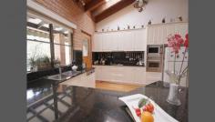 Roseville NSW 2069 There is plenty of scope for the growing family in this solid full brick family home. Architecturally designed and built in 1979, this home offers spacious formal and informal living areas. Full brick construction situated in a quiet child safe cul de sac with peaceful bushland views of Ku-ring-gai National park on 825 (approx) m2 of land. Features include: * Generous sized main bedroom with ensuite * 3 additional bedrooms, two with large built in robes * Formal dining room flows to lounge with 16' cathedral ceilings * Modern kitchen with granite benches and plenty of cupboard space * Large open plan family area adjacent to the kitchen including a separate area with wood burning slow combustion fire * Beautiful black butt timber floors throughout the family and bedroom areas * Spacious double lock up garage with level entry to the family room and kitchen * Downstairs is a large area suitable for home business, in law accommodation or self contained granny flat the option is yours