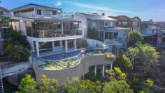 5 Highview Ave Queenscliff NSW 2096 An architectural triumph of the highest calibre, this as-new
contemporary masterwork leaves nothing undone in its quest to provide
the ultimate luxury retreat. Immersed in a sweeping 180 degree northerly
panorama with stunning ocean views, its premier headland setting is
within a few minutes stroll of the beach and village. Tri-level full brick residence with every conceivable luxury Vast open living, dining and family area with gas fireplace Glass bi-fold doors open to in/outdoor entertainers' deck Poolside family room with wet bar flows to covered patio Sophisticated Quantum Quartz island kitchen with butler's pantry Master suite with walk-in robe, ensuite and northerly deck Steam room, 3,000 bottle climate controlled wine cellar Chic bathrooms with heated underflooring, powder room Internal lift to all floors, Sydney red gum flooring, ducted air con Easycare garden with irrigation and automatic heated pool systems Stroll to Freshwater Beach and village, minutes from schools Double lock up garage, media centre, Dynalite smart system, comfort plus glass