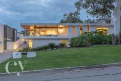 61 Sydenham Road, Doubleview, WA 6018 RARE-TO-MARKET MID-CENTURY MASTERPIECE Iconic properties such as this rarely change hands - this one has had just three owners since it was built in the 1960s. Offering a dramatic first impression with its cantilevered terrace, white-rendered facade, graceful eucalyptus trees and vast sweep of lawn, it reveals itself as a beautifully realised example of mid-century modernism, reminiscent of the glamorous homes of LA and Palm Springs. The floor plan makes the most of elevated city views from the deep tiled terrace and formal living room. At one end of the adjoining family room is the near-new kitchen with sleek, contemporary finishes, a scullery, and restful long views, making it a space that is open and enjoyable to cook in. The home's four bedrooms are conveniently separate from the living areas. The main suite has an ensuite, plus a balcony looking out over the street through eucalyptus trees. Three more bedrooms run along a separate wing and share a family bathroom with simple stone tiling, a deep tub and a separate shower. The home's hallways and living areas feature a gallery hanging system for displaying art work. The back of the house wraps around the home's amazing freeform swimming pool. Surrounding stone tiling and timber decking provide plenty of space for relaxing and enjoying the views of the glassy blue water, understated tropical plantings of palms and frangipani, and an original grotto. Tucked away to the rear of the block is a self-contained studio, which offers the potential to extend further, adding an ensuite and kitchenette, and could also be accessed from the sealed laneway at the rear of the house, making it perfect for multi-generational living or a home office. Beneath the house are a triple garage, temperature-controlled wine cellar and workshop, and extensive storage space, all tucked neatly away in an undercroft area. This remarkable home is sure to appeal to fans of modernist architecture, and its proximity to the coast and location high on Doubleview hill with breathtaking views add to its appeal. Be sure to register your interest early as history shows it won't be on the market for long! * Rarely available mid-century modernist family home * Four double bedrooms with built-in robes * Two spacious linked living areas with tiled terrace and city views * Huge freeform central swimming pool set in landscaped gardens * Renovated modern bathrooms with stone tiles * Three-car undercroft garage plus cellar and storage * Two hallways with gallery hanging system for artwork * Contemporary chef's kitchen with scullery and city views * Established, manicured gardens front and back * Separate breakfast room or study overlooking pool * Elevated position on Doubleview hill * Self-contained 32 square metre garden studio * Close to beach, freeway to CBD and Woodlands Shopping Centre AUCTION: 20th May 2:30pm DEPOSIT: $100,000 due at the fall of the hammer SETTLEMENT: 20th June 2017