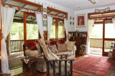 MALENY QLD 4552 $747,000 On a private and secluded 6,500 square metre block, only minutes from Maleny's main street, this delightful six bedroom timber pole home is filled with interesting features. Main living areas open to wide timber decks where you can relax and enjoy the native bird life and serenity of the beautiful bushland setting and the view over adjoining grassland. The heart of the home, a country style kitchen, features gas and electric cooking, ample bench space, dishwasher and a large pantry. There are three bathrooms, 9' ceilings, a slow combustion log fire and polished hardwood flooring. Downstairs has tiled flooring, air conditioning, lounge and a study plus two workshops. The home has a warm and inviting feel and would suit anyone looking for a home with style and character; it would also be ideal as a bed and breakfast venue. Inspection is a must to appreciate the charm and value of this delightful home and garden walkways.
