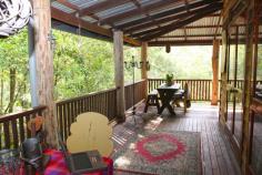 MALENY QLD 4552 $747,000 On a private and secluded 6,500 square metre block, only minutes from Maleny's main street, this delightful six bedroom timber pole home is filled with interesting features. Main living areas open to wide timber decks where you can relax and enjoy the native bird life and serenity of the beautiful bushland setting and the view over adjoining grassland. The heart of the home, a country style kitchen, features gas and electric cooking, ample bench space, dishwasher and a large pantry. There are three bathrooms, 9' ceilings, a slow combustion log fire and polished hardwood flooring. Downstairs has tiled flooring, air conditioning, lounge and a study plus two workshops. The home has a warm and inviting feel and would suit anyone looking for a home with style and character; it would also be ideal as a bed and breakfast venue. Inspection is a must to appreciate the charm and value of this delightful home and garden walkways.