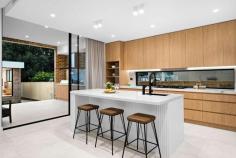 22 Smiths Avenue Hurstville NSW 2220 Placed in an elevated position on a peaceful, wide street this opulent residence is exceptional in its size and appointments, setting a new benchmark for homes in Hurstville. Enjoying a premier northerly rear aspect, it has been exquisitely crafted with not a single detail overlooked and the owner's vision clearly demonstrated through every element. From the moment you first see this home, you are sure to be captivated by the sheer scale of its interiors and long list of high-end fittings and you'll want to call it your own. - Grand entrance with custom front door reveals a dual level floor plan bathed in natural light - Light filled formal lounge starring a double void ceiling, designer pendant light and expansive windows - Open plan living/dining area with gas fire place, bespoke joinery, recessed lighting and curtains - Designer Range quartz kitchen featuring stunning curved island, walk-in pantry and window splashback - Stainless steel Bosch appliances including gas glass cooktop, dual ovens and dishwasher - Five plush bedrooms, all with built-in wardrobes, four on the upper level, three with ensuites - Grand hotel style master suite flows outdoors to sweeping balcony, the perfect parent's retreat - All four chic bathrooms include frameless showers, feature tiles and in-wall toilets, two have freestanding tubs - Home office/study with built-in desk and cabinetry; large laundry with stone benchtop - Generous covered entertaining area with outdoor kitchen overlooks level lawn and sparkling in-ground pool - Separate fully equipped pool cabana, ideal for alfresco entertaining - Double garage with automatic statement door and internal access plus ample space for storage - Ducted air-conditioning throughout, Billie instant hot cold water, security cameras and alarm - Within minutes of quality schools, shops, cafes, restaurants, recreational and transport facilities.