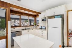 16 Adamson Cres Wanniassa ACT 2903 $949,000 Situated in an elevated position with sweeping views of the Brindabella's from the front, this lovely 3-bedroom home is set amidst mature gardens in the sought-after Wanniassa Heights. Set back privately on the large block or 1,101sqm, the front yard is fenced and private with a generous lawn area & a pergola-covered paved entertaining area, all taking in the panoramic views of the mountains ranges. Full-length verandahs flank the front & rear of the home, providing further spots to enjoy the view undercover as well as keeping the house cool and shaded in summer. Entering the home, you are greeted by the spacious lounge and dining area with a fireplace surrounded by a brick hearth for cozy winter gatherings. The light and airy updated kitchen has plenty of storage, an island bench & modern appliances including a dishwasher, & seamlessly adjoins onto a sunny tiled family area. Sliding doors provide access to the private rear garden which features lovely stone retaining walls. All 3 bedrooms are well-sized, two with the convenience of built-in robes & the family bathroom with a skylight plus separate toilet for added comfort. Original timber design features throughout the home add a warm look to the home and include timber-framed windows and timber sliding doors in every room. Wanniassa is popular with families for its established leafy streets, big blocks and a great community feel. It is within walking distance to Erindale shops, cafes and schools and only ten minutes’ drive to Tuggeranong or Woden. Features of the home include; 3-bedroom home Elevated block of 1,101sqm Built-in robes to 2 bedrooms Central family bathroom with separate toilet Large separate laundry with direct outdoor access Tiled family area with sliding door access to back yard Ducted reverse cycle air conditioning Modern kitchen with dishwasher and plenty of cupboard and bench space Double garage with remote Views of Brindabella's from the large enclosed & private front yard Spacious yard, ready for entertaining with pergola with BBQ & lawn area