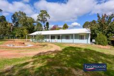 5105 Great Eastern Highway Mundaring WA 607 $839,000 Formerly a bustling plant nursery, this property has been transformed into a family home that will surprise and delight at every turn. The original nursery building has been reborn as a stylish studio that acts as a buffer and ensures the privacy and security of the modern, ranch-style home hidden at the rear of the block. This potential home/work site is surrounded by established plantings and ample space for kids and pets to run and play. A large, powered workshop and good off-street parking underline the potential and flexibility of this unique Mundaring property. 4 beds, 2 baths + studio 2014-built Hardi and iron OP kitchen/family/meals Formal lounge /media rm A/G pool, established gardens Gabled s-facing verandah 6 kW solar, rainwater tank Powered workshop/storage 1-acre work from home Private central location Hidden away towards the rear of the lot, the luminous Ross Squire’s home uses a palette of light colours, large windows and a flowing floorplan to fashion modern, ranch-style living. Front and rear verandahs, multi-use living zones, a spacious kitchen with a walk-in pantry and a boot room at the back door underscore a family-friendly design. The principal suite and junior wing sit on either side of the central open plan with a formal lounge and study nook leading to an expansive suite with a large bedroom, a walk-in robe and an ensuite. This layout allows the formal lounge to be styled as part of a large and indulgent parents’ retreat. A bright, neutral palette in the junior bedrooms brings a flexible backdrop suited to the embellishments of kids of all ages. A family bathroom and walk-through laundry complete the layout in the junior wing. Verandahs extend along the north and south faces of the home. To the north, a high gabled roof, wide paving and lush lily pillys fashion and secluded space for alfresco dining and entertaining. In the centre of the property sits an above ground swimming pool dressed in lush vine cover, it’s surrounded by established private gardens and provides plenty of room for kids to run free. The original nursery building has been transformed into a spacious and inviting studio with three rooms, a bathroom and a kitchenette: an enclosed backyard, a sheltered courtyard and a verandah fashion, a delightful and multi-purpose space. Adjoining the studio is a 14 m x 10 m powered workshop with a concrete floor and apron, two roller doors and a row of fixed storage along one wall. Roller doors at each end of the nursery building secure the home site and create an expansive private realm. Rich with possibilities for cultivating work-life balance, this property is minutes from public transport, the bustling Mundaring Village, and several private and government schools. To arrange an inspection of this property, call Lee Nangle – 0427 202 366.