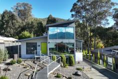 28 Fiddleback Drive Tawonga South VIC 3698 $1,500,000 - $1,600,000 Positioned in a picturesque Victorian High-Country valley is this extraordinary and ultra-modern home offering extensive unimpeded views of Mount Bogong and the Upper Kiewa Valley. This industrial themed and architecturally designed home features three bedrooms and two bathrooms with high end finishes, privacy, and elegance. Containing all the practicalities of modern living this property is set to impress and accommodate the demands of a wide range of purchasers. The breathtaking use of natural elements combine in a low maintenance front garden where slate stone flows featuring a dry creek bed with a modern fountain and gabion pillars which can be illuminated at night. An innovative above ground steel walkway reminiscent of a ski resort brings you to the remarkable entrance with a grand front door that welcomes you to this masterpiece of contemporary design unrivalled in scale, level of finish and sheer quality, this spectacular residence is unforgettable. This warm, luxurious tri-level home features extensive open plan living and is a banquet of bespoke design and detail with an industrial atmosphere comprising a lounge, kitchen, dining area and mezzanine above, all with stunning views of the surrounding countryside. The kitchen features top of the line appliances including an induction cook top on the large triangular island bench which has attached a glass breakfast bar. There is ample storage space in the kitchen with walk-in pantry, making it the perfect place for cooking and entertainment. The delightful adjacent dining area has an abundance of natural light from floor to ceiling tinted windows but transforms into an intimate and cosy dining area at night. Additional to the classic living areas there is a spacious upstairs mezzanine utilised as a sitting room offering spectacular unobstructed 180-degree views, day and night, of the Kiewa valley, Mount Bogong and the nearby township of Mount Beauty. A wonderful spot to sit and read a book or simply relax and drink in the view. Designed for grand scale alfresco entertaining the pool pavilion houses a heated 5-person spa, heated swim-jet pool with covers and a TV, perfect for all weather entertaining and being completely protected from the elements. The covered alfresco has an inside and outside counter connected to the kitchen by a bi-fold window to allow a seamless transition from indoor to outdoor living. It is an area that truly inspires and provides year-round poolside entertaining and an unparalleled lifestyle. The master bedroom is at the rear of the house and continues with the industrial and contemporary theme. Featuring a full room width, double access walk-in robe, an adjoining ensuite bathroom and large floor to ceiling windows looking out from the bedroom and ensuite over the large trees surrounding a flowing creek on the acreage behind the house. The subsequent two bedrooms are also substantial in size and have full width built-in robes. The third bedroom at the front of the house features large floor to ceiling window with spectacular views of the mountains. It is presently set up as a fully functional office/study but could be utilised as a bedroom if desired. The lowest level of the property is the most intricate containing a large workshop, garaging for 3 cars, a pool utility room containing washroom facilities and a room used as a garden shed with a separate entrance, all with concrete flooring and extensive built in cabinetry for storage facilities. Adjacent to the rear garage entrances is a large bituminous yard with ample space for a caravan, motor home or boat. The elegant gardens are low-maintenance with compact fruit trees and are auto drip irrigated for convenience. Additional features include, but are not limited to: • Double glazed windows throughout with large windows being lightly tinted with heat reduction and privacy film. • Instant hot water tap to a kitchen sink • Insinkerator in one kitchen sink • Professional reach and pull-out kitchen mixer tap • Extensive LED lights throughout • 30 solar panels with Tesla lithium battery backup • Home security alarm with outside video security cameras • Comprehensive audio-visual system with speakers and TV outlets throughout • 2x 6000litre rainwater tanks with submersible pump supplying water to toilets, laundry and some garden taps • Solar hot water service • Remote controlled automatic sliding gate to driveway entrance • Front bitumen driveway has additional off-street parking space • Garden shed under side of house • Large unused areas under floor of living area with potential for additional usable spaces for rooms or storage • Secure quality fencing for privacy The residence is situated on a small new estate with modern all underground services. The estate is 3km from Mount Beauty and is set in the middle of farmland and small acreages and is a mere 45 min drive from the snow at Falls Creek Ski Resort. The rural township of Tawonga is situated in the Kiewa Valley, North East Victoria in the Heart of the High Country. Tawonga is renowned for its majestic landscape and is central to a variety of recreational activities including fly fishing, horse riding, camping, water sports, downhill and cross-country skiing, snowboarding, golf, tennis, and mountain biking, bush walking, gliding, private aviation or simply absorbing nature. The region also boasts award winning restaurants and vineyards. The exterior of this property presents unique quality architecture, while the memorable interior spaces show an incomparable combination of sophistication, cutting edge design, and spectacular attention to details.