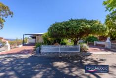 19 Oxley Pl Darlington WA 6070 $1.24 MILLION Dappled light dances along a quiet, secluded cul-de-sac leading to the carriage driveway of this large family home with breathtaking views, zoned living, expansive outdoor living and entertaining space, a separate studio and a below-ground pool with a gazebo. A quintessential Darlington property with exceptional views, the home boasts generous proportions, formal and informal living and views that sweep from Boya across the plains to John Forrest National Park. • 5 bedrooms 3 bathrooms • 1984-built brick and iron • Formal lounge and dining • Open-plan kitchen/meals • Activity/media w projector • W-around alfresco w blinds • Freestanding studio space • Heated below-ground pool • 2122 sqm dual frontage lot • Secluded Hillside location Step inside to discover generously proportioned living spaces that seamlessly blend formal and informal areas, all enhanced by breathtaking views with almost every window framing exceptional vistas and bringing the outdoors in with abundant natural light and beauty. A separate junior wing comprising three bedrooms and a family bathroom is arranged at the front of the plan, along with a study with an entry from the garage. An ensuite bedroom with a corner window capturing fantastic views across the pool to the horizon offers ideal accommodation for an adult child or older parent. This large, carpeted room boasts reverse cycle air conditioning, a renovated ensuite and built-in robes. Central to the expansive floorplan is a large media/activity room with a fixed screen, an overhead projector, speakers and ample space for a pool table. Suited for multiple uses, the activity room has exterior access and double doors leading to the family room, where a slow-combustion fireplace and reverse-cycle air conditioning create a family hub that is comfortable and inviting year-round. The bright, modern kitchen is filled with panoramic views thanks to glazing on three sides. Crisp white cabinetry, above and below a large, U-shaped countertop, surrounds an electric cooktop, oven, and dishwasher. A servery hatch makes alfresco dining and entertaining a breeze. Adjoining the kitchen is a formal dining room and lounge, calm and sophisticated rooms featuring corner windows framing various aspects of the view. The main suite sits at the northern corner of the plan. It consists of a study/sitting room that could be styled as a dressing room, a large bedroom with direct access to the alfresco entertaining area, a bay window looking across the paved verandah, an ensuite and a walk-in wardrobe. The outdoor living and entertaining areas are as impressive as the interiors, offering expansive spaces to host gatherings and revel in the stunning location. The home’s wide veranda gives the impression of floating in the panoramic view. It wraps the front of the home and offers multiple spaces for entertaining and relaxing. A separate studio provides versatility as a creative workspace, guest accommodation, or a teens’ retreat. Completing this idyllic setting is a heated below-ground salt pool edged with a cabana and lawn. An atmosphere of welcome and generosity makes this a home where everyone wants to be. The kids and their friends will love the pool and yard, guests will be mesmerised by the views from the indoor and outdoor entertaining areas, and everyone will appreciate the media room with its large screen and projector, taking ‘Netflix and Chill’ to a new level. This is more than a home; it’s a haven where you can savour the best of Darlington living with unmatched style, views, and tranquillity. Around twenty minutes from Perth airport and thirty-five minutes from the CBD, this home is ideally located for commuting and offers easy access to a choice of schools.