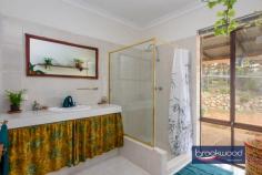 3165 Victoria Rd Hovea WA 6071 $949,000 Live connected to nature on this spectacular Hovea property located on the border of John Forrest National Park. Minutes from Hovea Falls and kilometres of walking and riding trails, the 3 bedroom 2 bathroom home sits in a natural landscape with a canopy-level balcony that makes it feel like a treehouse. Fruit trees, vegetable gardens, rainwater tanks, solar panels and a storage battery lighten your footprint while the availability of scheme services provides security. This mesmerising environment is an idyllic habitat for humans and creatures, and the appearance of resident kangaroos, Red Tail Black cockatoos, Boobook Owls, Quendas and Echidnas is a thrilling reminder of the richness and rare beauty of nature. 3 bedrooms 2 bathrooms 1984 built brick and iron Multiple living zones Indoor-outdoor floorplan N-facing tree-top balcony Pwd workshop auto retic 6 kW solar 9.7 kW battery Decked above-ground pool 2 ha block paved driveway Spectacular natural oasis Moving through the landscape to arrive at this Hovea home feels like ascending to another realm, a secret world where native flora and fauna and the rhythms of nature direct and enrich each day. Cocooned by a degree of self-sufficiency and with endless opportunities to play, explore and discover the natural environment; this property delivers the shelter of a warm and inviting home and the nourishment and inspiration of a stunning and unique Hills location. The home displays a modern organic vibe with predominately neutral material and colour palettes interrupted by bursts of rich, warm colours and the use of robust natural materials. A central open plan bathed in light from a skylight, flows seamlessly to a formal entertaining space – currently used as a music room – and a north-facing sunroom with full-height glazing. The sunroom opens onto the verandah spanning the front of the home to create an all-season, indoor-outdoor living space that appears to float in the treetops and views to the decked gazebo and sparkling swimming pool. An intrinsic connection to nature is seen across the home, in the granite feature wall behind the slow combustion fire, the tactile, organic form of wooden handles on the kitchen cabinets, and the smooth, textured surface and subtle colour shifts of slate floors. In the beating heart of this home lies an updated modern kitchen, replete with stone benchtops, a suite of stainless-steel appliances and abundant storage. The master suite is positioned discreetly at the front of the home with polished concrete flooring and sliding door access to a wide verandah. Complete with a walk-in robe and semi-ensuite connecting through to the living hub. The junior wing housing two large bedrooms, a light filled family bathroom and walk-through laundry is tucked to the rear of the home. A commitment to stepping lightly is evident across the property. Reticulated vegetable gardens, wicking beds, fruit trees, and a chicken run bring self-sufficiency. Scheme water is available, and power is connected. Still, rainwater tanks, solar panels and a storage battery reduce dependence on the grid, and a large, powered workshop with 3 open bays provides a practical space for at-home projects and repairs. With 4.94 acres to explore and John Forrest National Park, The Heritage Trail, Eagle’s View walk and Hovea Falls at the bottom of the driveway, days of adventure and wonder await. Bike and walking trails in the national park have been extended and subjected to considerable upgrades in recent months, with further improvements planned. More sedate pastimes can be found at the much-loved Parkerville Tavern, an easy, level walk away along the Heritage Trail. It is rare to find a property of this character, a home that meets the ideal of Hills living so completely with the space and freedom of a 4.94-acre lot, adjacent to a national park, within easy reach of schools and Mundaring Village yet shrouded in the blissful beauty of nature and a sense of isolation.