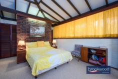 19 Cook St Darlington WA 6070 $779,000 Capturing the essence of 1970s design, this eye-catching family home showcases iconic features synonymous with the era – think exposed brick and beams, a raked ceiling and a floorplan revolving around a central atrium. The interior exudes warmth with its timeless timber built-ins and panels, complemented by the organic tones and texture of slate floors. This extraordinary home is now offered for sale for the first time in over five decades, presenting a unique opportunity to infuse new life and modernity. 3 bedrooms 2 bathrooms 1970’s built home Raked ceilings exp beams Extensive built-in storage Upstairs flexible living room Ducted vacuum system Powered work space + woodshed Paved drive double carport 2340 sqm elevated block Walk to Helena College Step through the grand double doors into a formal foyer, where slate flooring sets the tone for authentic 70s style. To one side, a generously proportioned living area beckons, while on the other, a formal dining room and a well-appointed kitchen await. The living room is an ode to relaxed sensibilities; it features a soaring raked ceiling adorned with exposed beams. Dual-aspect glazing fills the airy space with light and provides a view of the central atrium and the front garden. A slow-combustion fireplace and reverse-cycle air conditioning ensure year-round comfort, creating a harmonious blend of style and functionality. The formal dining room, with windows looking onto the atrium, leads into the kitchen and breakfast nook overlooking the front garden and surrounding natural landscape. The kitchen has electric appliances and boasts a large built-in pantry and split system air conditioning. A short flight of stairs leads from the living room to the main bedroom, a good-sized space looking onto the atrium with built-in storage and an ensuite with a shower, vanity and WC. The junior bedrooms, a study nook, and a family bathroom complete the bedroom zone layout. Both minor bedrooms have built-in storage and raked ceilings and benefit from a second slow-combustion fireplace. The flue of this second fireplace extends into the upstairs living area, a flexible area with multiple uses. The spacious second-storey extension with north-facing windows, built-in cabinets, and a wet bar is an ideal family room, guest accommodation, or teens’ retreat. It is not impossible to see this space transformed into an indulgent parents’ retreat with enviable tree-top views. Access to the under stairs wine cellar located on the exterior of the home, adds to the charm and a great use of space with built in wine bottle holders. The home is paved on all sides with a courtyard area to the southern side where you can settle in and enjoy the afternoon glow of the sun setting through the trees. A small, powered workspace sits at the top of the block. A space where your ideas and hobbies can come to life. Such a versatile area or can purely be used for extra storage and gardening tools. A woodshed located to the side with a lean-to roof, designed to keep yourself and the wood dry through the winter months. This move-in-ready property presents a canvas of possibilities with a coveted Darlington address, original features and a flexible floorplan, extending an invitation to reimagine the home’s potential. To those with a discerning eye, the intact seventies features offer a springboard to create a truly striking Hills home. Seize the moment to embark on a journey of renewal, establish a presence in this highly sought-after locale and embrace contemporary living in a fusion of iconic design and modernity.