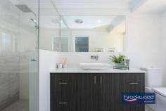 4 Damascus Dr Greenmount WA 6056 $810,000 Experience a lifestyle shift to hills living with this splendid 4 bedroom, 2 bathroom home that has undergone an extensive renovation, on a 907 sqm family friendly block. 4 bedrooms 2 bathrooms Brick & Colorbond home Modern quality fittings Formal & informal living Ducted evap cooling Dbl C/Port & w/shop area Alfresco entertaining Large below ground pool Fully fenced, 907 sqm Foothills location The property boasts a thoughtful layout with both formal and informal living spaces, highlighted by a central open plan area, leading to an expansive alfresco entertaining zone and a below-ground pool in the secure fully fenced backyard. The attractive family home is situated in a fabulous foothills location surrounded by towering palm trees, a well-manicured lawn, and a decked portico featuring an oversized timber and glass front door. The grand front entry unfolds to reveal a formal lounge with timber-look floors, creating an inviting space for entertainment or quiet retreat from the central living zones. The lounge is complemented by an impressive main suite on one side, featuring a shiplap wall, plush carpet, a fully tiled ensuite, and a spacious walk-in wardrobe—all designed with luxurious finishes. The heart of the home is a well-conceived open plan kitchen/family/meal area with quality stone benchtops, an integrated breakfast bar, hi-gloss tiled splashback, separate pantry and top-of-the-line appliances. The family room is enhanced by plush carpet and wainscoting, offering a cozy atmosphere, while a gas imitation woodburner and modern ducted evaporative cooling ensure year-round comfort. A separate junior wing houses three bedrooms, two with robes and one with a built-in desk, accompanied by a fully tiled family bathroom and a walk-through laundry with ample bench space and storage. A sliding door from the open plan living area leads to a spacious alfresco entertaining area with a timber-lined ceiling, fan, and slow combustion fire. The poolside space is generously proportioned, accommodating a large table, BBQ, and even a bar fridge cavity. The below-ground pool, adorned with paving and a reticulated green lawn, adds to the outdoor allure.The property is equipped with a large, secure storage/workshop space at one end of the outdoor entertaining area which is adjacent to the remote-access 2-car garage. Strategically located in Greenmount, this address provides easy access to good schools, shops, the airport, and arterial links, coupled with the nearby National Park, making it an ideal choice for those seeking the beauty and adventure of Perth Hills living.
