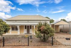 27 Railway Terrace Nuriootpa SA 5355 Discover the perfect blend of historic charm and modern convenience in this stunning 1890 symmetrical cottage, nestled on a generous 1011m² block with commercial/employment zoning. This versatile property offers a unique opportunity to enjoy a residential haven or pursue commercial endeavors, subject to council approvals. Step inside to be greeted by a spacious entrance featuring elegant jarrah flooring and soaring 3.4m ceilings. The large master bedroom is a serene retreat with a beautiful bay window and cozy fireplace, while the second bedroom is equally spacious, ensuring comfort for all. The modern bathroom includes a separate toilet for added convenience. The heart of the home is the expansive family room, seamlessly connected to a contemporary kitchen. Here, you'll find a two-drawer dishwasher, ample cupboards, and generous bench space, perfect for culinary enthusiasts. The laundry is exceptionally spacious, offering abundant storage solutions. Comfort is assured year-round with three reverse cycle split systems and gas heating throughout the home. Double doors open to a decked outdoor entertaining area, complete with a BBQ area and plumbed water, ideal for hosting gatherings. A standout feature is the fully-equipped granny flat, perfect as a teenage retreat, studio, or workspace. It includes a bedroom, bathroom, kitchenette, split system, ceiling fan, instant gas hot water, and a verandah, providing a self-contained living space or business opportunity. The exterior boasts beautiful gardens, a single carport leading to a single auto door garage, and ample large shedding, neatly fenced away from the house gardens, offering plenty of storage and workspace options. Situated within walking distance to the Nuriootpa shopping precinct and a short commute to the renowned Barossa wineries, this property combines convenience with a desirable lifestyle. The commercial/employment zoning provides flexibility, whether you envision a charming residence or a commercial venture. Embrace the rich history and modern amenities of this remarkable property, offering endless possibilities in the heart of Nuriootpa. Don't miss the chance to make this versatile cottage your new home or business headquarters.