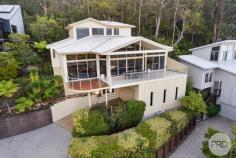 9 Tareebin Road Nelson Bay NSW 2315 Poised atop a hill sits your new home, where luxury meets tranquillity in a stunning modern architect-designed masterpiece. This split-level sanctuary is a testament to meticulous craftsmanship, offering a seamless blend of contemporary design and natural beauty. As you approach, you'll be greeted by lush landscaping that perfectly frames the striking facade of the residence. Step inside to discover a world of refined elegance, where outstanding finishes and meticulous attention to detail create an atmosphere of unparalleled sophistication. Large, picturesque windows adorn the living spaces, offering awe-inspiring views of the headland and the tranquil waters of Port Stephens. Bathed in natural light, the interior boasts polished stringy-bark timber floors and stairs, lending a warm and inviting ambiance throughout. The heart of the home is the modern gourmet kitchen, featuring top-of-the-line Miele appliances and sleek stone benchtops. Whether you're a culinary enthusiast or simply love to entertain, this space is sure to inspire creativity and delight your senses. Step outside onto your spacious balcony, where privacy meets panoramic views. Enjoy alfresco dining or simply unwind as you soak in the breathtaking vistas stretching across Port Stephens and beyond. Retreat to the master bedroom and parents' retreat, complete with a private balcony overlooking the serene nature reserve. The remaining two bedrooms are generously proportioned, offering comfort and convenience with ceiling fans and built-in wardrobes. With a large double lock-up garage and carport providing ample space for vehicles and visitors alike, convenience is never compromised. And thanks to the low-maintenance gardens, you'll have more time to savour the idyllic lifestyle that this property affords. Immerse yourself in the ultimate blend of luxury, comfort, and natural beauty at one of the best-sited properties in Port Stephens. Welcome home to a life of unparalleled tranquility and refinement.