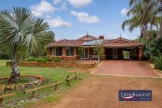 33 Whitehall Rd Hazelmere WA 6055 $1,400,000 This stunning 3.2-acre property offers a dream country lifestyle just 16km from Perth CBD. Highlights include various sheds and an awesome workshop, a large fenced paddock, multiple outdoor entertaining areas, and lush gardens. With a welcoming entrance and numerous features, it’s hard to know where to start. The light-filled home features open-plan living and a formal lounge/dining area. The master bedroom, with bay window, offers stunning garden views, a walk-in robe, and a spacious en-suite. The formal lounge and dining area lead to a renovated kitchen with designer appliances and a shopper’s entry from the double carport. The family room and meals area, warmed by a wood fire, overlook the kitchen. Three king-sized bedrooms with built-in robes are located down the hallway, alongside a bathroom and laundry. The highlight of this rare property is the usable 3.2 acres. Fed from a plentiful bore, the land surrounding the home can stay green all year round. You will definitely need a ride on mower to keep the parkland gardens looking their best. Subject to approval, you could have a horse, park a truck, run a business or you could simply enjoy the privacy that this acreage property provides. Enjoy outdoor gatherings under the wrap-around patio, with views of the expansive lawn and fenced paddock. The property includes a 100sqm powered workshop with a mezzanine and hoist, plus a large shed with double roller doors. Features include: Fully fenced with double front gates Massive workshop with 4T car hoist Circular driveway, double carport and shed Lush lawns and tropical gardens Undercover parking for caravans or boats Wrap-around entertaining and large gabled patio Spacious master bedroom with bay window Modern kitchen with breakfast bar Open-plan family and meals areas with wood fire Ducted air conditioning, solar panels Just a short drive to Midland Shopping Precinct and 10 minutes to Perth Airport, this home offers a blend of country charm and city convenience.