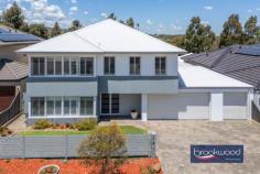 12 Drovers Way Jane Brook WA 6056 $1,000,000A luminous beacon atop Jane Brook’s Highland Range Estate, this strikingly handsome home uses a palette of subtle colours and limited materials to create interiors that resonate with refined balance and harmony. With its impeccable presentation and floods of natural light, the property unfolds with an air of understated elegance, seamlessly blending comfort and modern luxury. Framed by reticulated gardens and a three-bay garage, it opens up to sweeping, south-facing views of the distant hills, grounding the contemporary design in the timeless beauty of nature. 4 beds 2 baths 3 WC study 2013-built brick and iron Hills views & city glimpses Family-focussed floorplan Upstairs open-plan living Spacious junior bedrooms Large study/5th bedroom 3-bay garage to backyard 589 sqm reticulated block Height of sophistication This meticulously designed family home greets you with a sense of calm and sophistication. The double front door opens into a welcoming foyer, where ash-coloured laminate flooring seamlessly pairs with crisp white wainscoting and walls in a refined putty hue, setting a tone of understated elegance that flows throughout the plan. To the right of the entry lies a versatile walk-in storeroom, complete with open shelving – ideal for organised storage or, as the current owners have done, an ironing room. The thoughtful design continues with a full-height double linen press and a spacious walk-through laundry featuring a stone benchtop and ample under-bench storage, prioritising practicality without sacrificing style. Three generously proportioned junior bedrooms occupy the ground floor, each outfitted with built-in or walk-in robes and plantation shutters. The family-friendly bathroom, which includes a tub, shower, and vanity, serves the bedrooms, while a separate powder room provides added convenience for busy mornings. Completing the ground-floor layout is a bright sitting room with sliding doors opening to the south-facing backyard. This outdoor area is a beautifully landscaped space for relaxation or play with reticulated lawns edged with garden beds and a paved entertaining area wrapping the rear of the home. A small garden shed adds functional storage, enhancing the property’s low-maintenance appeal. Ascending the central staircase, the open-plan living zone unfolds in a bright, neutral palette that enhances the home’s luminous, airy feel. A south-facing balcony extends from this central living space, framing captivating views of the distant hills and glimpses of the city beyond. Year-round comfort is assured, with reverse-cycle air conditioning, a ceiling fan, and a modern slow-combustion fireplace anchoring the space. The heart of the living area is a meticulously designed kitchen featuring a stone-topped island with an integrated breakfast bar and an array of deep storage drawers. Culinary enthusiasts will appreciate the 5-burner gas hob, twin electric ovens, and dishwasher, all in place to elevate the cooking experience and entertaining. Ample overhead and under-bench cabinetry and a built-in pantry add to the impressive storage options throughout the home. The kitchen’s south-facing sink enjoys breathtaking views, transforming even the most mundane tasks into moments of relaxation. Towards the front of the first-floor plan, a spacious study with a north-facing bay window framed by plantation shutters offers abundant natural light and flexibility. Its proximity to the principal suite makes it an ideal nursery, serene guest room, or separate media room. The principal suite is a masterclass in refined calm, enveloped in blue-grey walls, ash floors, and elegant white trim. This parents’ retreat boasts an ensuite reminiscent of a boutique spa, complete with a stone-topped double vanity, a luxurious rainfall shower, and a modern soaking tub – creating a tranquil escape within the home. This beautifully conceived family home offers an elevated approach to modern living. It is defined by subtle elegance, practical design, and thoughtful details, providing space for family life and entertaining alike.