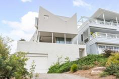 107B The Drive Stanwell Park NSW 2508 $3,000,000 Perched on the front row, with one of the most prestigious addresses in Stanwell Park, this spectacular property offers you beachside living at its finest! A modern, executive residence, it showcases the best that Stanwell Park has to offer: encompassing panoramic views from the tree-lined escarpment and pristine parklands, to the rolling waves of the Pacific Ocean, and the distant, twinkling lights of Wollongong city. HOME: • No expenses were spared in constructing this architectural masterpiece with the attention to detail amongst the best that we've seen on this coastline. The closer you look, the more impressed you will be. The use of natural materials such as stone and timber, along with the seamless flow between indoors and outdoors, evokes a sense of harmony with the beautiful surroundings, while the modern features, including heated floors and ducted aircon, ensure that you are not lacking any modern comforts. • It is evident that the architect has tried to incorporate breathtaking views into every area of the house, and the kitchen is no exception. Preparing meals becomes a pleasure instead of a chore in this designer kitchen with Carrara marble benchtops, quality appliances and a picturesque escarpment backdrop. • For those who value their time, the home offers a very low-maintenance lifestyle. This attribute makes it a perfect option for a downsizer, as a beachside holiday home, or perhaps a home base for people who would like freedom to travel and experience more of what life has to offer. • Spend those warm summer days enjoying a glass of wine on the front deck while taking in the impressive views, or perhaps entertaining friends and family in the private rear courtyard surrounded by native landscaped gardens. • The master bedroom, complete with ensuite, built-in wardrobes and a private deck, provides you with a serene escape after a long day. It effortlessly balances views, privacy, style and practicality. • Keep the rising electricity bills to a minimum with 9kw of solar panels and integrated Tesla Powerwall 2 battery. • The generous tandem double garage opens into a huge storage room, providing you with plenty of secure space for your cars along with all of your boards, bikes, etc. • All of the hard work has been done for you. All that is left to do is move in and begin enjoying your new coastal lifestyle! LOCATION: • An inspection is a must to truly appreciate the magnificence of this location, only steps from the pristine Stanwell Park beach, which is fully patrolled, offers fantastic surf breaks and is dog friendly. • Stanwell Park offers quaint village charm that is becoming increasingly rare in today's society. A peaceful and relaxing lifestyle surrounded by friendly faces is what Stanwell Park is all about. • Watch hang gliders floating above Bald Hill, families enjoying the park, and surfers carving through the perfectly formed waves… all from the comfort of your own home. • Leave the car at home, as the local cafe's, school, shops, and restaurants are all only minutes from your front door. • The Royal National Park is situated just beyond the top of the hill - 10 minutes drive. • Stanwell Park is situated approximately 1 hour South of Sydney CBD and approximately 30 minutes North of Wollongong CBD. • Embrace the quintessential coastal lifestyle and all that comes with it... swimming, fishing, bushwalking, hang gliding, and family picnics in popular parklands all available only moments from your doorstep.