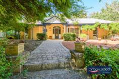 11 Hawkstone Street Gidgegannup WA 6083 $1,200,000 A gently graded landscape rolls from the road to a hidden glen and quality-built family home surrounded by ample outdoor living and entertaining space. The home boasts a flowing floorplan, formal and informal living and dining high ceilings and a bright neutral palette. 4 bedrooms 2 bathrooms 1990-built brick and iron High ceilings throughout Open plan & formal living Multi outdoor entertaining Principal suite private patio Separate jnr bedroom wing Powered studio & workshop 5-acres with high-yield bore Hideaway with convenience A wide stone staircase leads to the home’s front door and formal entry, but the south-facing door into the open-plan living zone most often welcomes friends and family. This casual, friendly welcome sets the tone for a relaxed, family-focused lifestyle. Approached via a wide stone staircase, the home’s formal entry has a sense of grandeur and sophistication. Yet, the backdoor – opening from a south-facing patio embodies the true spirit of this welcoming residence. Step inside via this ‘friends’ entrance, and the luminous style of the open-plan kitchen, meals, and family room immediately embraces you. Parquet floors run underfoot, and large windows to the north and south fill the room with natural light and garden views. A slow-combustion fireplace casts a cosy glow, and split-system air conditioning ensures year-round comfort. High ceilings emphasise the volume and ease of the flowing floorplan, setting the stage for a relaxed, family-oriented lifestyle. A thoughtfully designed kitchen beckons with its stone-topped island and breakfast bar– ideal for morning coffee or casual meals. Surrounding the electric oven and cooktop, an L-shaped benchtop provides ample workspace, while a dishwasher, extensive cabinetry, and a large walk-in pantry keep the space pristine and organised. The formal living and dining rooms extend from the main entry. Here, polished parquet floors gleam in the light of an open fireplace, creating an atmosphere of warmth and refinement. Adjoining the lounge, the formal dining room connects to the south-facing patio, perfect for alfresco dining or evenings spent entertaining. From the open-plan hub, a private junior wing offers a quiet retreat. Three well-appointed bedrooms – two with carpets and built-in robes, one with parquet flooring – provide a flexible backdrop for the tastes and needs of kids of all ages. Featuring a claw-foot bathtub, the family bathroom has a measure of old-fashioned charm. A walk-through laundry with abundant storage and a separate WC complete the layout in the junior wing. Picture yourself waking up in a serene primary suite, where French doors open to a verandah draped with wisteria. This is your private haven, complete with plush carpeting, a split-system air conditioning unit, and a spacious walk-through robe leading to an ensuite featuring a double vanity, a shower, and a WC. Set on a 5-acre lot, this home is a sanctuary of privacy and possibility. Imagine strolling through arbours, enjoying the changing seasons in the gardens, or retreating to the powered brick studio for creative pursuits. A powered workshop provides ample space for projects or hobbies. The property is as functional as it is beautiful, with a productive bore and filtration system supplementing generous rainwater tanks, a choice of nearby schools including Mundaring Christian College, Parkerville Primary School, Parkerville Steiner School and Silver Tree Steiner School along with school pickup on Roland Road. The nearby Parkerville Tavern is a family-friendly local, and the Gidgegannup township boasts a much-loved bakery, local doctors, a chemist, and fuel. Midland and Mundaring, with their extensive services and amenities, are both an easy drive away. Whether you’re seeking space for work, play, or to unwind, this property delivers on every level. Designed for modern living with a home filled with peace and tranquillity. Welcome home.