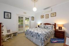 11 Hawkstone Street Gidgegannup WA 6083 $1,200,000 A gently graded landscape rolls from the road to a hidden glen and quality-built family home surrounded by ample outdoor living and entertaining space. The home boasts a flowing floorplan, formal and informal living and dining high ceilings and a bright neutral palette. 4 bedrooms 2 bathrooms 1990-built brick and iron High ceilings throughout Open plan & formal living Multi outdoor entertaining Principal suite private patio Separate jnr bedroom wing Powered studio & workshop 5-acres with high-yield bore Hideaway with convenience A wide stone staircase leads to the home’s front door and formal entry, but the south-facing door into the open-plan living zone most often welcomes friends and family. This casual, friendly welcome sets the tone for a relaxed, family-focused lifestyle. Approached via a wide stone staircase, the home’s formal entry has a sense of grandeur and sophistication. Yet, the backdoor – opening from a south-facing patio embodies the true spirit of this welcoming residence. Step inside via this ‘friends’ entrance, and the luminous style of the open-plan kitchen, meals, and family room immediately embraces you. Parquet floors run underfoot, and large windows to the north and south fill the room with natural light and garden views. A slow-combustion fireplace casts a cosy glow, and split-system air conditioning ensures year-round comfort. High ceilings emphasise the volume and ease of the flowing floorplan, setting the stage for a relaxed, family-oriented lifestyle. A thoughtfully designed kitchen beckons with its stone-topped island and breakfast bar– ideal for morning coffee or casual meals. Surrounding the electric oven and cooktop, an L-shaped benchtop provides ample workspace, while a dishwasher, extensive cabinetry, and a large walk-in pantry keep the space pristine and organised. The formal living and dining rooms extend from the main entry. Here, polished parquet floors gleam in the light of an open fireplace, creating an atmosphere of warmth and refinement. Adjoining the lounge, the formal dining room connects to the south-facing patio, perfect for alfresco dining or evenings spent entertaining. From the open-plan hub, a private junior wing offers a quiet retreat. Three well-appointed bedrooms – two with carpets and built-in robes, one with parquet flooring – provide a flexible backdrop for the tastes and needs of kids of all ages. Featuring a claw-foot bathtub, the family bathroom has a measure of old-fashioned charm. A walk-through laundry with abundant storage and a separate WC complete the layout in the junior wing. Picture yourself waking up in a serene primary suite, where French doors open to a verandah draped with wisteria. This is your private haven, complete with plush carpeting, a split-system air conditioning unit, and a spacious walk-through robe leading to an ensuite featuring a double vanity, a shower, and a WC. Set on a 5-acre lot, this home is a sanctuary of privacy and possibility. Imagine strolling through arbours, enjoying the changing seasons in the gardens, or retreating to the powered brick studio for creative pursuits. A powered workshop provides ample space for projects or hobbies. The property is as functional as it is beautiful, with a productive bore and filtration system supplementing generous rainwater tanks, a choice of nearby schools including Mundaring Christian College, Parkerville Primary School, Parkerville Steiner School and Silver Tree Steiner School along with school pickup on Roland Road. The nearby Parkerville Tavern is a family-friendly local, and the Gidgegannup township boasts a much-loved bakery, local doctors, a chemist, and fuel. Midland and Mundaring, with their extensive services and amenities, are both an easy drive away. Whether you’re seeking space for work, play, or to unwind, this property delivers on every level. Designed for modern living with a home filled with peace and tranquillity. Welcome home.