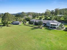 23 Julie Way Mudgeeraba QLD 4213 $5,990,000 Crowning 2.84 hectares of pristine Gold Coast hinterland, this architectural masterpiece embodies timeless modern homestead style while offering the perfect balance of tranquil rural living with exceptional convenience—just 5 minutes from the M1, Robina Town Centre and top schools, and only 15 minutes from pristine beaches. Arriving home to Magnolia House, you're immediately embraced by a sense of peaceful luxury and effortless elegance. The stunning primary residence unfolds across 766m² of meticulously designed space, offering 6 bedrooms, 5 bathrooms, and a wealth of striking features. Soaring 3m ceilings, herringbone oak floors, heritage style windows, and dramatic limestone feature walls are complemented by soft black accents and cool cross-breezes, creating an atmosphere of refined sophistication throughout. Step inside to discover multiple living zones orchestrated for both grand entertaining and intimate family moments. The heart of the home opens to reveal magnificent open-plan living and dining zones, where an abundance of windows and doors welcome the outside in, framing stunning views of the estate and surrounding bushland. Skylights bathe the space in natural light, while striking fireplaces serve as both a visual anchor and gathering point during cooler evenings. The designer kitchen is set behind a vast breakfast bar that offers a level of comfort that seems to simply call the family to gather. A stunning barn door stylishly conceals a butler's pantry zone with integrated dishwasher and double sink, however the open plan nature of the kitchen allows breezes and light to move freely through the space. Premium fixtures, bespoke cabinetry, and high-end appliances cater to both everyday meals and sophisticated entertaining. An abundance of farmhouse style windows offers the perfect vantage point to remain connected to the covered entertaining deck, or simply gaze across the valley to the silhouette of distant mountains. Multiple outdoor living spaces extend the home's footprint into the natural environment. The main entertaining deck provides a commanding position to appreciate the property's elevation, with seamless transitions between interior comfort and alfresco living. Here, sunset gatherings become magical experiences as the changing light plays across the valley below. Sunset views from here are especially striking, as the changing light creates a dramatic display across the valley below. This space has become a favourite with both family and guests, used year-round thanks to cooling breezes in summer and a wood-burning fireplace that provides warmth and a cozy gathering place during cooler months. The bedroom zone is thoughtfully housed in its own wing. The sumptuous master suite offers a private sanctuary with extensive robes and a spa-like ensuite that opens onto its own private courtyard. Thoughtfully positioned to capture the morning light, this retreat flows onto the covered balcony where you can begin each day with breathtaking views as kangaroos dance across the lawn. Additional bedroom suites are generously proportioned and strategically placed to provide both connection and privacy for family and guests. The property's bathing spaces deserve special mention, with designer fixtures, luxurious freestanding tubs, and premium finishes throughout. Several feature dramatic connections to the outdoors, allowing for a sense of bathing in nature while maintaining complete privacy. Outdoor living reaches its zenith with the sprawling resort-style swimming pool featuring a cascading waterfall that provides a soothing soundtrack of running water that carries throughout the main living zones. Adjacent to the pool sits an additional covered deck area, perfectly positioned for poolside entertaining or simply watching the play of light on water while enjoying the vista. Surrounding gardens blend manicured areas with natural bushland, creating a harmonious transition between architectural elements and the untamed beauty of the Australian landscape. Throughout the property, thoughtful touches reveal themselves – from the climate-controlled wine cellar, to the purpose-built gym and yoga studio, the oversized triple garage, additional storage, and comprehensive solar power system. Each element has been considered not just for its function but for how it enhances the overall living experience. This extraordinary estate is complemented by multiple additional dwellings and infrastructure, creating endless possibilities for business-minded buyers. A second residence with it's own private driveway is ideal for those seeking additional rental income. This free standing home features three bedrooms, two bathrooms, and outdoor entertaining spaces overlooking its own sparkling pool. A luxurious shed conversion delivers an additional one-bedroom studio, ideal for accommodating extended family and guests. While a versatile workshop provides 127m² of space with an air-conditioned office zone, bathroom, kitchenette and workshop/vehicle accommodation. HIGHLIGHTS - PRIMARY RESIDENCE Luxury homestead style 6-bedroom, 5-bathroom home with study and gym Soaring ceilings, herringbone timber floors, cedar leadlight windows Vast kitchen with Butler's pantry set behind a barn-style door, breakfast bar to seat 5, Neff induction cooktop, SMEG pyrolytic double oven, and integrated dishwasher Luxurious bathrooms with exquisite details from leadlight windows to clawfoot bathtubs Fireplaces in two living zones, and primary suite Transtherm multi zone wine cabinet to temper, chill, and store wine Ducted reverse cycle Air Conditioning Crimsafe + security system in place Resort style pool with waterfall Extensive covered alfresco areas with lounge, dining, and cooking zones overlooking pool and grounds 3-car garage 15Kw Solar HIGHLIGHTS - SECOND RESIDENCE Currently tenanted on a periodic lease 3 bathroom, 2 bedroom home in original condition Salt water pool Fully fenced Independent driveway access HIGHLIGHTS - STUDIO Luxury shed conversion 1-bedroom self-contained apartment HIGHLIGHTS - MACHINERY SHED/OFFICE BUILDING 21m x 6m shed Dedicated zones for a workshop, office, bathroom, kitchenette Split-system air-conditioning HIGHLIGHTS - LAND 2.84 Ha / 7.01 Acres of stunning land with landscaped gardens and established trees 86,000L water tanks + town water available Additional carports and driveway space 3 cascading spring fed dams The estate's position offers the perfect balance of seclusion and convenience, with Gold Coast's pristine beaches just 25 minutes away, international airport access in 35 minutes, and Brisbane within a 90-minute drive. Yet despite these connections, the property maintains a sense of peaceful removal from the bustle of urban life. This extraordinary offering presents a rare opportunity to acquire one of the region's most prestigious estates where architectural excellence meets natural splendor – a place where every day feels like a retreat, yet with all the functionality needed for modern family life.