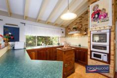 305 Old Farm Ln Stoneville WA 6081 $1,249,000 Offered for sale for the first time since construction, this much-loved and lovingly tended family home is a joy to behold. Surrounded by thriving bore-reticulated gardens dotted with shady arbours and nooks, this impeccably presented home features open-plan living, a separate junior wing and a floor plan designed for indoor-outdoor living. Large windows, a palette of natural materials and colours and judiciously selected antiques balanced by modern convenience produce an utterly bewitching home ready and waiting for a new family and generations of memory-making. 3 bedrooms 2 bathrooms 1996-built brick and iron Open plan w raked ceiling Solar array/RC/SS air con Huge decked outdoor living Drive-in powered workshop Bore-fed auto reticulation Artist’s studio garden office Landscaped 4079 sqm block Nestled amidst exuberant, meticulously curated gardens – a magnificent antique French fountain at its heart – this enchanting property invites you to experience a lifestyle of tranquillity and connection to nature. A bull-nose verandah extends across the front of the home, its generous width creating an inviting outdoor living space. Here, mornings with coffee and watching native birds flit around the garden offer an unparalleled start to the day. Stepping inside, the formal entry sets a tone of welcome and generosity. To one side, the principal suite is a private sanctuary. Carpeted floors, reverse-cycle air conditioning, and a large walk-in robe ensure modern comfort, while the ensuite celebrates classic refinement with a 6-foot clawfoot tub from the early 1900s and antique-style tapware—a nod to the home’s timeless character. At the heart of the home, the expansive open-plan living area unfolds beneath a raked ceiling, with large windows framing views of the rear garden and entertaining deck. The kitchen, thoughtfully designed for family life, features jarrah cabinetry, a U-shaped benchtop, a double electric wall oven, a 4-burner gas hob, and a built-in pantry. Whether it’s casual weeknight meals or festive gatherings, this space seamlessly adapts to the rhythms of daily life. Set adjacent lies the dining and lounge areas -comfortable warm spaces, centred around an inbuilt fire place, mantlepiece and framed by Woodbridge brickwork. French doors open to a stunning decked entertaining zone, effortlessly linking indoors and out. The junior wing, accessed via a bright and spacious hallway, offers two Queen sized, carpeted bedrooms with built-in robes, a heritage style family bathroom with a shower and tub, a separate WC, and ample storage. A laundry/mudroom with garden access completes this functional yet inviting area of the home. Outside, the gardens come alive in every direction. A gabled roof shelters the expansive deck spanning the rear of the home, which overlooks a backyard that feels like a private wonderland. A wisteria-covered arbour leads you through a shaded glen, across a bridge over a pond, and to a stationary 1968 Globetrotter caravan. Styled as a multi-use garden retreat, it’s a space limited only by your imagination—a home office, a teen’s hideaway, or a summer sanctuary. Practicality meets creativity at the rear of the property, where a side access driveway leads to a large, powered workshop and an expansive covered hardstand provide storage for up to six vehicles room for hobbies or projects. A brand-new 6.6 kW solar array adds energy efficiency, while the gardens, fruit trees and vegie beds flourish with a bore-fed reticulation system and a 13,000-litre tank (approx.). An artist studio/ garden office space set to the rear of the enclosed double carport completes this beautiful 4079 m property. This is more than a house – it’s a home that brings together the best of indoor-outdoor living, timeless design, and an exceptional garden setting in a faultless backdrop to generations of making memories.
