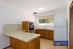 24 Bellevue Rd Bellevue WA 6056 $725,000 This solid 1975 brick-and-tile home sits on a generous 680-square-metre block zoned R20/40, offering immediate liveability with genuine potential for those who see beyond the mauve bathroom tiles. The bones are good, the layout works, and there’s space to move – both inside and out. A powered workshop, substantial verandah, and private backyard complete a package that rewards practical thinking. 4 bedrooms, 1 bathroom 1975-built brick and tile Well-proportioned living Open-plan kitchen meals 6 m x 6 m powered shed Private fenced backyard 16 m x 3 m rear verandah Drive through BY access Zoned R20/40, 680 sqm lot 15 minutes to Perth airport The formal entry from the tandem carport leads through an arched doorway into an air-conditioned lounge room that’s surprisingly light and well-proportioned. Timber-look floors underfoot and a picture window overlooking the backyard create an airy feel that belies the home’s modest street presence. The open-plan kitchen and meals area continue the functional approach. Timber-look cabinetry, laminated benchtops, and an integrated breakfast bar define the cooking zone, which is fitted with an electric oven, new dishwasher, never used and a built-in pantry. Nothing revolutionary, but everything you need is here and sensibly arranged. The meals area accommodates a proper dining table with room to move, and the outlook to the backyard makes morning coffee feel less rushed than it probably is. Four carpeted bedrooms branch off a central hallway in classic 70s fashion. The main bedroom comes with air-conditioning, a ceiling fan, and a wardrobe, providing a comfortable retreat. One of the junior rooms includes a robe recess. The shared family bathroom embraces its era with mauve fixtures and tiles that someone, somewhere, is now paying premium prices to recreate. A separate WC sits off the walk-through laundry, a practical arrangement that eliminates morning bathroom queues. The backyard is where this property distinguishes itself. Double gates at the rear of the tandem carport provide drive-through access to a 6-metre by 6-metre powered workshop tucked into one corner – a space serious enough for projects, storage, or tinkering. A row of trimmed fiddlewood trees lines the rear boundary, their canopies creating a green screen that erupts with fragrant flowers come spring. The fully fenced lawn extends from an 16-metre verandah running the full width of the home’s rear, providing multiple zones for outdoor living. Palm trees frame a partially enclosed gazebo that previously housed a spa but reads more readily as an outdoor kitchen in waiting. Add a barbecue, some string lights, and comfortable seating, and you’ve created the kind of entertaining space that keeps people outside long after the sun sets. The privacy here is genuine – the kind where neighbours exist but don’t dominate your sightlines. The R20/40 zoning adds another dimension to the proposition. For those who see this as a long-term hold, there’s development potential. For those who want space now, the 680-square-metre block delivers elbow room. The location offers practical advantages too – Perth Airport sits roughly 15 minutes away via direct highway access, making early flights less punishing than they might be from elsewhere. This isn’t a home that will seduce you with European appliances or Instagram-ready interiors. It’s a solid, honest property that works now and offers options for later. The reward here is space – to live, to work, to potentially develop – at a point where space itself has become a luxury. For buyers who value function over fashion and see potential where others see only bathrooms that time forgot, this represents genuine opportunity.