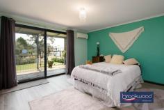 33 Tamarillo Ct Bakers Hill WA 6562 $949,000 An as-new Colorbond steel framed home set on 3.26 acres of park-like acreage planted with deciduous trees for shade, natives for wildlife habitat and jacarandas for summer colour. This property delivers genuine space – inside and out – with a three-bedroom primary residence, separate one-bedroom accommodation, two paddocks and the kind of big sky that reminds you what evening light actually looks like. Reclaimed materials meet contemporary country style throughout, from Art Deco leadlight windows to repurposed farm machinery that lends structure to the garden. 3 bedrooms, 2 bathrooms Colorbond Queenslander home Open-plan kitchen/family/meals Fantastic activity/games room Generous interior spaces Wrap-around verandah Sep 1 × 1 accommodation 2 paddocks, sheds, chooks 3.26 level acres fenced 3-meter-wide verandahs The main residence sits proudly elevated, with reclaimed Art Deco leadlight windows screening the corners of the wraparound verandah. Entry is via a wide staircase framed by multicoloured recycled paving. The thoughtful reuse continues—an old bedhead repurposed as a balustrade, and disused farm machinery cleverly lending structure to garden beds. An inspired material palette and a clear eye for making things work give this home genuine personality. The open-plan kitchen, family, and meals area feels genuinely spacious. A 900 mm freestanding self-cleaning oven anchors the kitchen, finished in soft blue cabinetry with marble-look benchtops and a grey subway-tile splashback. Hybrid flooring runs across the entire plan, connecting kitchen to meals to family room in a continuous flow that makes the space feel larger than its footprint and handles the inevitable traffic of daily life without complaint. The meals area opens directly to the southern verandah – breakfast outside becomes routine, not an occasion. A large casement opening and double-sided Jarrahdale slow-combustion fire, with a pressed-metal surround, link the central living area to the adjoining activity room. Timber floors and generous proportions make this a great, open space where a pool table fits comfortably, creating a laid-back spot for family fun, entertaining and unwinding together. The principal suite claims the front corner of the plan, a bay window framing views across the acreage. The room is generous – king-size bed, space for a reading chair, split-system air conditioning, and direct deck access. The ensuite features a relaxing spa bath, a detail that transforms a standard evening into a genuine wind-down. Two junior bedrooms share the family bathroom – one a double, the other a large king with reverse-cycle air conditioning and its own deck access. The family bathroom includes both a shower and a tub, with a separate WC accessed via the walk-through laundry. The laundry itself uses a moody palette, continuing the contemporary country aesthetic that runs throughout. The separate accommodation elevates this property. A large verandah with outdoor blinds leads to a multi-use room with a pitched roof, slow-combustion fire, evaporative cooling, and a kitchen corner. This space could serve as additional accommodation for visiting family, a teenager’s retreat that offers everyone breathing room, or a home-based business office /showroom. A sheltered outdoor fire pit extends the usable space – somewhere to gather on clear nights when the stars do all the talking. The large bathroom/laundry and partially enclosed rear room (ideal as bedroom or office) add genuine flexibility. Outside, the 3.26 acres delivers fenced paddocks – one with shelter – provide scope for a pony, alpacas, or simply the peace that comes with room to breathe and move. The chicken coop is in place. A woodshed, garden shed, carport, and an old bus converted to a storage room. The property runs a 5-kW solar array and connects to scheme water, supplemented by a small rainwater tank. The acreage itself has been planted with trees for shade and jacarandas that announce summer in violet. The garden incorporates recycled elements throughout – a creative approach that gives the property character. Bakers Hill township sits five minutes away – enough distance to feel separate, close enough that milk runs don’t become expeditions. Northam is 20 minutes, Mundaring 25 minutes, Perth Airport approximately 50 minutes. This is the Wheatbelt fringe – close enough to Perth for work commutes, far enough out that the night sky actually matters. The property suits anyone seeking space without isolation, contemporary comfort without suburban compression and the particular satisfaction of hearing birdsong rather than traffic as the day begins.