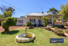 42 Broome Terrace Northam WA 6401 $749,000 Opposite the Avon River, behind a white picket fence and a garden planted with lavender and roses, sits a home that was built to last. The deep verandah, the jarrah floors, the 11-foot ceilings with their decorative cornicing – nothing here has been lost in the name of renovation. What you get instead is a generous, characterful early twentieth-century home on a 1692 sqm riverside block and a floorplan that has plenty of room to adapt to whatever you need it to be. 3 bedrooms 1 bathroom Rendered brick and iron Riverside overlooks Avon Striking 11-foot ceilings Glorious jarrah floorboards Flexi FP space hm business Manual retic front garden Drive-in fenced backyard 1692 sqm level fenced lot Walk the bridge to town Step through the gate and up the arching front steps to a deep, shaded verandah. Morning coffee here, watching the Avon meander past, sets the tone of life in a big country town. Inside, the integrity of the original build is immediately apparent. Jarrah floorboards in rich ox-blood tones run across much of the plan, 11-foot ceilings with decorative cornicing and ceiling roses amplify every room, and the formal lounge – anchored by a slow combustion fire set into the original hearth – balances period character with a modern neutral palette and split-system air conditioning. A pair of glass doors connects this room to the verandah, so the line between inside and out blurs easily. The eat-in kitchen is generously proportioned, with a freestanding oven set within the white-tiled original hearth, overhead and under-bench cabinetry along one wall, and ample room for a family table. At the end of the central hall, a carpeted multi-purpose room opens onto a sizeable rear verandah and alfresco – it could be a formal dining room, a playroom, or a media room; the brief is yours to write. The principal bedroom sits at the front of the plan – large, calm, fitted with built-in robes, plush carpet, and a ceiling fan, it looks out to the fountain and front garden. A second junior bedroom sits nearby. This junior room has glass doors leading to a sunken wing of two spacious rooms with a separate entry – currently used as a home office and gym. This is where the property’s flexibility really shines: a home-based business, a guest suite, a teenager’s retreat, or a combination of all three. The rear of the property is fully fenced, with drive-in access through gates at the back of the double carport. A Colorbond shed and lean-to occupy one corner, a Jacaranda tree shades the built-in barbecue, and the level yard is a blank canvas – vegetable garden, pool or landscaped entertaining space. This is part of Northam’s historic residential precinct – an area rich in late nineteenth- and early twentieth-century character. Iwan Iwanoff’s striking Public Library is nearby, as is the heritage-listed Northam Flour Mill and the Northam Railway Station. The Avon River suspension footbridge is a short stroll away and leads to Northam’s main street with its heritage shopfronts, cafes, and essential services. Perth CBD is a comfortable day-trip of just over an hour’s drive. Perth Airport sits approximately 90 km away. For those who commute occasionally rather than daily, the Avon Valley lifestyle makes the distance easy to absorb. Northam draws visitors from Perth for the Avon Descent, hot air ballooning over the valley, and the town’s own considerable heritage appeal. Living here is a different pace – not remote, not a compromise, but a considered choice.