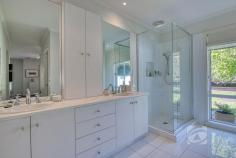 14 Valley Dr Beaconsfield Upper VIC 3808 $2,100,000 - $2,300,000 Park-Like Living, Perfected Set on a beautifully maintained acre of landscaped grounds, this substantial residence presents a rare opportunity to secure a foothold in one of the area’s most tightly held and sought-after enclaves. Privately positioned on the flat side of exclusive Valley Drive and backing directly onto a pristine nature reserve, the property offers an exceptional sense of space, tranquility and prestige. Framed by established trees and lush gardens, the grounds create a peaceful sanctuary that blends seamlessly with the adjoining reserve. Rich with birdlife and thoughtfully curated, the landscape provides a picturesque setting for both outdoor entertaining and quiet moments of relaxation. The 21-year-old Porter Davis home is generously proportioned and thoughtfully designed, offering a flexible floorplan suited to a variety of lifestyles. Multiple living zones, both formal and informal, are filled with natural light, with well-positioned windows drawing the surrounding greenery inside. At the heart of the home, a well-appointed stone kitchen connects effortlessly with the sunlit family and dining areas, creating a warm hub for everyday living. Accommodation includes four oversized bedrooms, highlighted by a spacious master suite with walk-in robe and private ensuite featuring a double vanity. A versatile retreat adjoining the master could easily function as an additional living area, home office or fifth bedroom depending on your needs. Additional features include plantation shutters, new carpet, ducted heating, evaporative cooling, split system air conditioning, solar panels, ducted vacuum and internal access to the remote double garage. French doors open to alfresco entertaining overlooking the beautifully established gardens, showcasing an impressive collection of around 70 species including Chestnut trees, Japanese Maples, Golden Ash, Silver Birches, Canadian Maples and Lemon trees. With mains water, shedding, a double carport in addition to the garage and a unique “wine gate” connecting to the neighboring property, this is a home designed for both lifestyle and connection. Homes of this calibre in such a prestigious and tightly held location are rarely offered, providing a lifestyle of space, privacy and natural beauty just moments from local schools, shopping and transport.