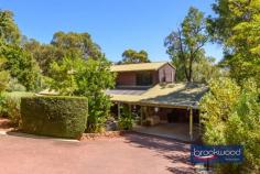 17 Duncan Pl Mahogany Creek WA 6072 $1,300,000 There are Hills properties, and then there are Hills homes – the kind shaped by years of considered care, where every corner reflects a deliberate choice to showcase its qualities. Set at the end of a private cul-de-sac in one of the Darling Range’s most quietly coveted pockets, this solid jarrah-and-iron character home has thoughtfully evolved into something genuinely special: a split-level family sanctuary that balances privacy with connection, liveability with style and character with charm. 4 bedrooms, 2 bathrooms 1989-built jarrah & iron Spacious split-level design Fantastic cooks’ kitchen First-floor parents’ retreat Stunning outdoor room Powered 6 x 9m workshop Auto retic, Solar and RC SS 1800 sqm landscaped lot Trails, schools, transport close The home’s two-storey design oozes style and is set across several levels, with a floor plan that gives each member of the household room to breathe. From the sealed and kerbed driveway – flanked by rock-retained gardens and a water-feature atrium – the entry opens upstairs to a generous parents’ retreat and primary suite, or steps down through the heart of the home toward the rear. It’s the kind of house you feel yourself settle into as you move through. The parents’ level is its own domain: a formal lounge or sitting room alongside the primary bedroom, cocooned yet connected by muted tones and plantation shutters featuring built in robes and a spa ensuite. Downstairs, three large junior bedrooms each include storage options; the largest “the Wood Room” is framed by a large picture window and opens through French doors to a private deck overlooking the bush reserve beyond – the sort of room a teenager never wants to leave. They share a neat family bathroom featuring a bath, shower, vanity and a separate WC. At the centre of the home, a magnificent kitchen anchors daily life with purpose. A granite-topped island bench with breakfast bar and second sink overlooks the atrium and patio; glass-fronted display cabinets, ample storage, a plumbed fridge, and a dedicated workstation make this a kitchen that takes cooking – and family life – seriously. A Neff double oven, Miele dishwasher, and Asko cooktop complete the picture. The adjoining laundry – calm, considered, with built-in storage – carries the same design conviction and flows seamlessly. Stepping down to the vast family living area, high raked ceilings and large picture windows create a sense of openness. A slow-combustion fire anchors winter evenings; Reverse cycle split system air-conditioning manages the summer months. French doors connect the living room to a spectacular outdoor room – with a span roof, sub-floor insulation, retractable screens, and remote-controlled doors on either side fashion an all-season space for gatherings large and small. Behind the home, a powered 6m x 9m Colorbond workshop with a 6m x 3m covered bay awaits the enthusiast, tradie, or hobbyist, with limited vehicle access through the rear reserve. Two water tanks supply fresh rain water to the home, automatic reticulation system currently running on scheme water, that sustains the extensive native gardens and sweeping lawn, which, along with rock walls and meandering pathways, cross the generous 1,800 sqm block. Mahogany Creek sits quietly in the Hills, a community with a deep connection to its surroundings. The Heritage Trail runs close by, and a bush reserve backs directly onto the property. Families are well-served by a strong selection of schools – Mundaring Primary, Darlington Primary, and Eastern Hills and Swan View Senior High Schools are all within easy reach. Mundaring Village – with its cafés and community facilities – is a comfortable 10-minute drive; Midland city centre is approximately 20 minutes. Perth CBD is about 45 minutes away, and Perth Airport is roughly a 35-minute drive – making this a genuine Hills address that doesn’t require you to sacrifice the city entirely. For families looking for a home to grow into – one with space, soul and surroundings to match – this one is hard to look past.