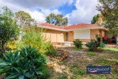 735 Lilydale Rd Chidlow WA 6556 $2,000,000 Development sites don’t usually come with a below-ground pool and fruit trees. These five acres in Chidlow are a different kind of proposition with R5 zoning, sealed roads, mains water and a comfortable home already on site. The land can be subdivided into up to nine 2000 sqm blocks (subject to council approval), the infrastructure is largely in place and you can live on-site and store machinery and equipment in the sheds while the whole project unfolds. 3 beds 1 bath 2 WCs 1960s brick & tile build Comfortable & updated Ducted RC AC & solar Live on-site & develop Subdivide into 9 blocks (STCA) Mains water & sealed road Level site · five sheds 5.27 ac / 2.13 ha · R5 zoned Walk school, pub & lake The land runs east to west, from Lilydale Road to Well Loop – and when this subdivision goes ahead, it will close the gap between the north and south branches of Well Loop, completing the circle. That’s not incidental. Sealed roads exist for all but the final connection, mains water is available and the R5 zoning permits 2000 sqm lots. The pieces are in place – what’s needed now is a plan and someone with the appetite to execute it. The three-bedroom, one-bathroom home sits on one of those potential lots, which means you’re not losing a block by living here; you’re using it. Rent it out while you wait on approvals, or move in and watch the project take shape from your own back porch. Either way, the house earns its keep. It’s a 1960s brick-and-tile – and a good one. Jarrah floors in the living areas, carpeted bedrooms, well-proportioned rooms, built-in robes and a mid-century fireplace that sits at the heart of the home exactly as it was always meant to. The original owners have updated and extended it over the years without losing the thread: an open-plan kitchen and meals area, a built-in verandah, a gabled outdoor entertaining space that doubles as a carport. The additions feel considered rather than tacked on. Outside, there are five sheds on the level site – one in particular is in good condition, well-suited to storing equipment and machinery throughout the development phase. There’s also a below-ground pool, generations-old fruit trees heavy with the promise of a good season and old rose bushes that look like they’ve been here since the beginning. This is a site that has been well-loved. That history doesn’t disappear with a subdivision – it becomes the foundation for whatever is next. The primary school, pub, post office, skate park and community garden are all within walking distance of the site. Lake Leschenaultia is close by, with a quiet walking track and water activities. The Heritage Trail is minutes away, offering serious kilometres of walking and riding without getting in the car. The development case is clear. So is the sense of place. When the subdivision is done, and Well Loop finally closes, both of those things will still be true – and the circle, in more ways than one, will be complete.