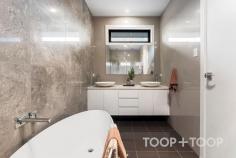 96A Reid Ave Magill SA 5072 $1,680,000 Welcome to 96A Reid Avenue, an extraordinary corner-block residence in the heart of Magill, South Australia. Bathed in natural light and defined by refined modern design, this home offers an immediate sense of calm, space, and understated elegance. Set within one of Adelaide’s most tightly held eastern suburbs, it delivers a sophisticated family lifestyle with architectural excellence, generous proportions, and effortless livability throughout. As you approach, the sleek exterior with its soft neutral tones offers a glimpse of the beauty within. Upon entering, you are greeted by a spacious lounge that flows effortlessly into an open-plan living and dining area. This space is framed by large windows, ensuring every corner is bathed in natural light. The home is thoughtfully designed with three distinct living areas, providing flexibility for everyday living, entertaining, and relaxation. The ground floor features a beautifully appointed master suite with walk-in robe and ensuite, offering privacy and comfort—ideal for guests, extended family, or multi-generational living. Upstairs continues the sense of space and functionality, featuring a second master retreat with walk-in robe, ensuite, and bathtub. Four additional upstairs bedrooms complete the accommodation, including three with built-in robes and one bedroom (adjacent to the balcony) without a built-in robe, offering flexibility as a study or additional living space. This level is further enhanced by a private balcony aspect, a well-appointed central bathroom, and an upstairs retreat with a built-in bar, including provisions for a fridge and tap—creating the perfect space for entertaining, relaxing, or hosting guests. At the heart of the home, the open-plan kitchen, living, and dining zone connects seamlessly to the outdoor entertaining area and rear yard, complete with artificial lawn and a private putting green—delivering a low-maintenance yet highly enjoyable lifestyle setting. The kitchen, a chef’s dream, boasts top-of-the-line appliances, high-end stone benchtops together with a statement stone island bench elevate the kitchen with timeless style and practicality. A standout feature of the home is the fully integrated whole-house filtered water system, providing purified water to every tap throughout the property, including bathrooms and showers. Perfectly located close to quality schools, parks, shopping precincts, cafés, and public transport, this exceptional residence presents a rare opportunity in a tightly held eastern suburbs pocket. Key features: -Constructed with rendered brick throughout, the home offers a solid build, excellent durability, and an elegant contemporary finish -Corner-block residence set on approximately 452sqm -Total living area approximately 364sqm -Ground-floor master suite with walk-in robe and ensuite -Upstairs master suite with walk-in robe, ensuite, and bathtub -Four additional upstairs bedrooms, three with built-in robes -Private balcony aspect from upstairs level -Upstairs retreat with built-in bar (fridge & tap provisions) -Three separate living areas including upstairs retreat -Gourmet kitchen with quality appliances and stone island bench -Open-plan living and dining area flowing to outdoor entertaining -Impressive 3-metre high ceilings downstairs creating a grand sense of space and natural light -Low-maintenance backyard with artificial lawn and private putting green -Fully integrated whole-house filtered water system -Security alarm system -Three-phase power for enhanced electrical capacity -13.2KW solar panel system with 27KW battery storage -Instantaneous gas hot water system -Secure double garage complete with panel lift entry and high-quality epoxy floors, alongside additional off-street parking for family and guests -Conveniently located near quality schools and local amenities -Walking distance to public transport -Easy access to The Parade, Firle Plaza, and Adelaide CBD -Close proximity to parks, cafés, and recreational facilities Whether you’re seeking a luxurious family residence in Magill or an investment opportunity with strong long-term appeal, this exceptional home is perfectly positioned to meet your needs.