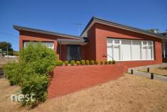 243 E Derwent Hwy Lindisfarne TAS 7015 $690,000 Inspection Times 25-Jul-2026 11:00am to 12:00pm With sleek street appeal and facing into a cul-de-sac, this 50s brick home ticks the boxes of convenient living, easy access to the city and a choice of leisure activities nearby. Walk to a selection of schools in the area, Lindisfarne Village, Natone Hill or around the stunning foreshore of Geilston Bay and Lindisfarne, which can take you all the way to Tasman Bridge and beyond. Sandstone paving creates an attractive first impression, with a porch at the front door, and hedge plantings which draw you in. Walking into the wide entrance hall with timber floors and a large linen cupboard, the layout leads to semi-open plan living on the right and bedrooms and bathrooms to the left. There are two single bedrooms and a large double. All have new carpet and come with built-in wardrobes. The master has an updated light and airy ensuite. The family bathroom has been strikingly renovated with dark, moody tiling contrasting the white walls and fixtures. Two large mirrors reflect light, boosted by a skylight. The ceiling heater-light provides extra comfort. A massive lounge room features a wall of windows, traditional cornices and a timber panelled wall at the end with a well-placed Daikin reverse cycle air conditioner to heat the whole zone. The dining area, connecting kitchen to lounge, has a glass sliding door leading to the outdoors – great for entertaining! The kitchen incorporates all new, quality appliances, double sink, excellent pantry space and a beautiful textured tile splashback spanning the ample bench and cabinet space. The laundry is connected to both the kitchen and back door for easy clothesline access. The outside has been landscaped and slightly terraced, with block pavers and pebbles to set off the yard. A fully-fence area of lawn and mature trees means you can have that family dog and kids can play safely. Under house storage is perfect for all those gardening tools, bikes or could be made into a hobby space. Only ten minutes to the CBD, renovated and all on one level, this property could make the ideal home for a couple or young family.